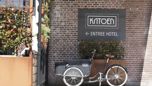A sign for Kaitoen Entree Hotel with a bicycle parked in front. - Hotel & Brasserie Katoen (Goes)