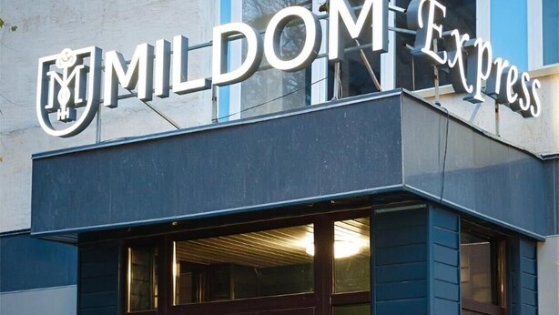 A building with a dark facade and a sign reading "MILDOM EXPRESS".
