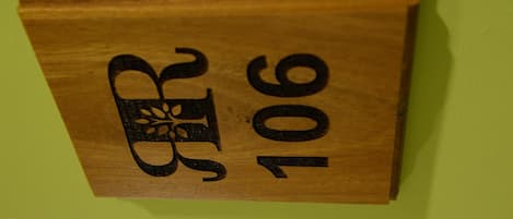 Una placa de madera con un diseño decorativo y el número 106.