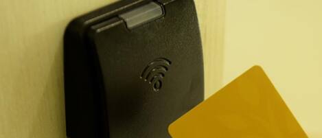 A hotel room door with a keycard reader and a keycard.