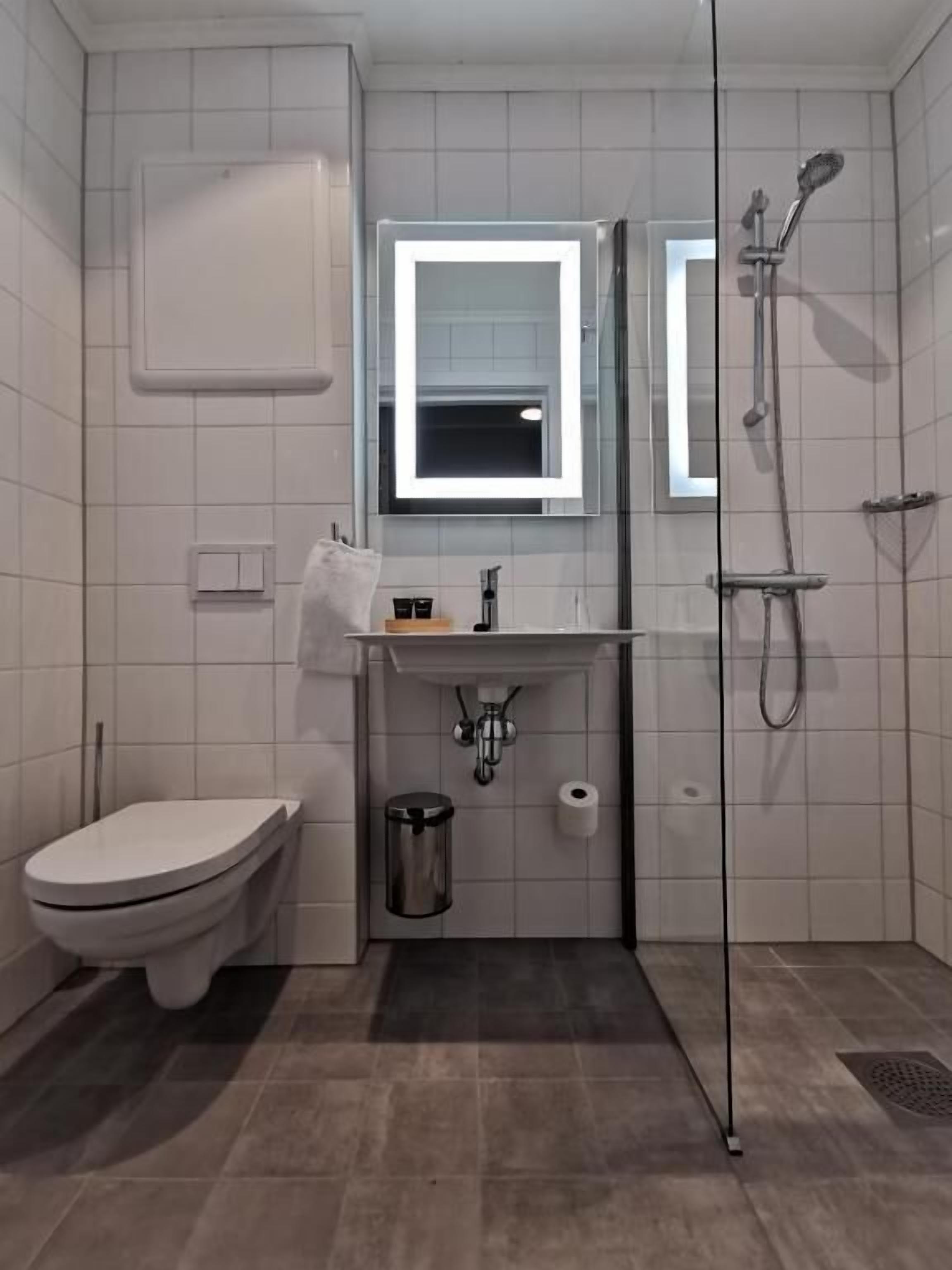 Ein modernes Badezimmer mit Toilette, Waschbecken und Dusche.