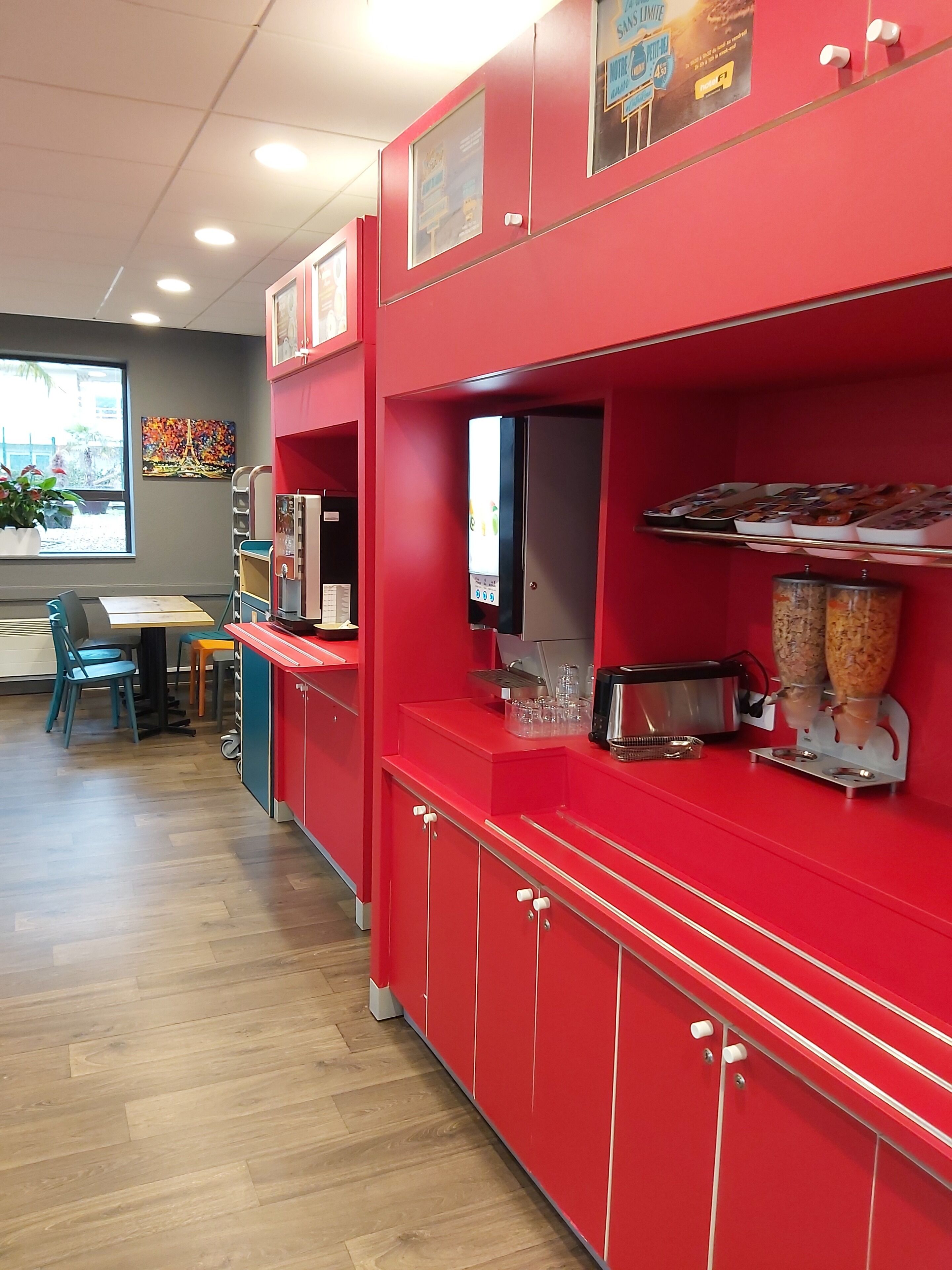Un área de servicio de alimentos con mostrador, microondas, tostadora y dispensador de bebidas.