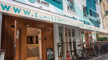 Ein Hostel mit einer Holzfassade, einem Empfangsbereich und einem Schild, das einen Empfangstresen kennzeichnet.