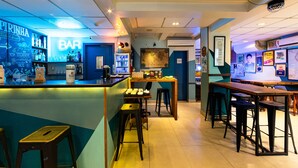 Una zona de bar con un letrero de neón, estantes con botellas y taburetes.