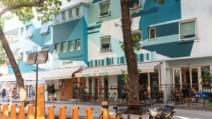 Un hostal con fachada geométrica, asientos exteriores y una bicicleta estacionada.