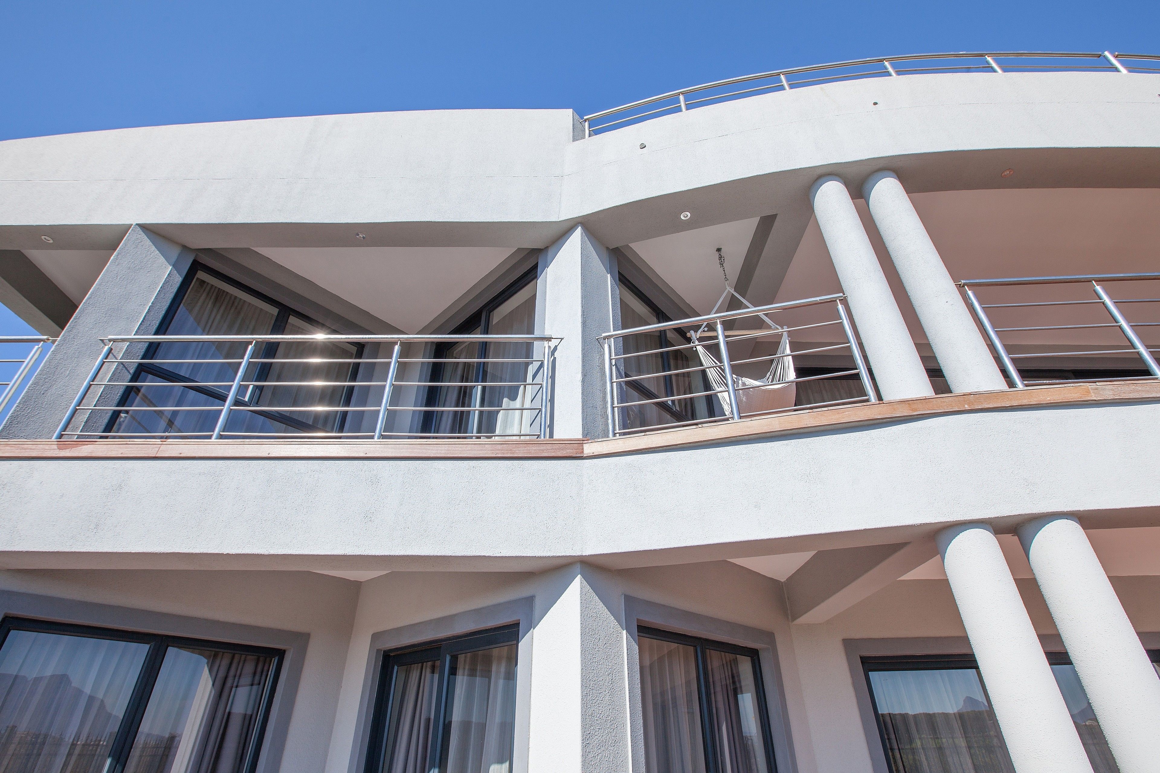 Ein modernes Gebäude mit mehreren Balkonen, großen Fenstern und einer geschwungenen Fassade.