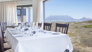Ein Esstisch, gedeckt für eine Mahlzeit, mit Blick auf eine Berglandschaft.