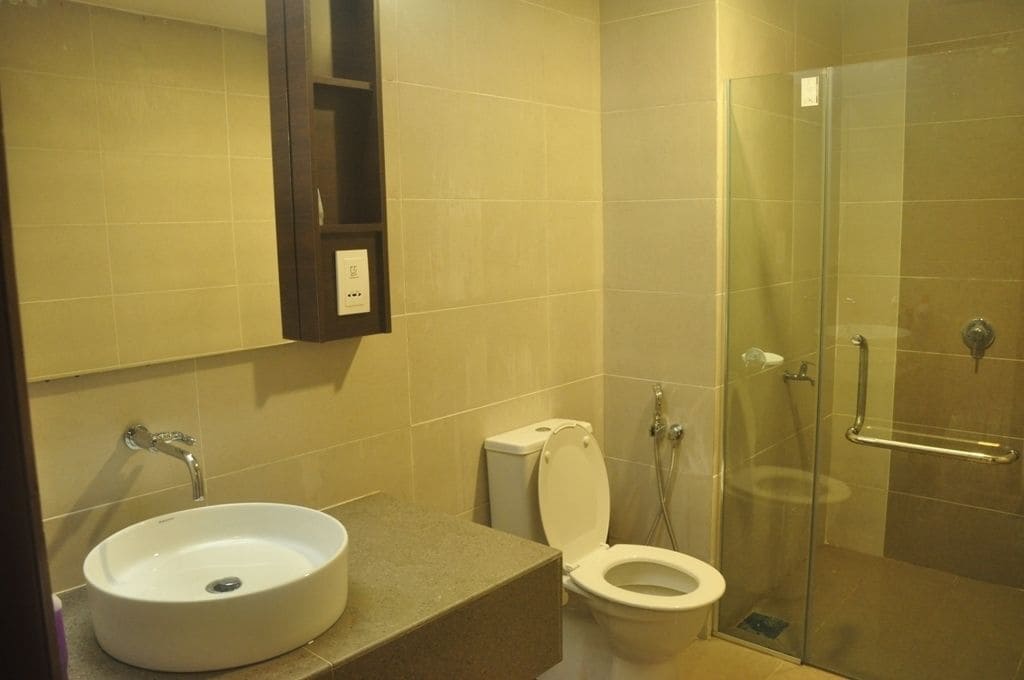 A bathroom with a sink, toilet, and glass shower enclosure.