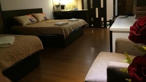 A hotel room with two beds, a desk, a chair, and a mirror. - AL-Aidid Homestay (Kota Bharu)