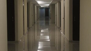 A long, narrow hotel corridor with doors on both sides and a tiled floor. - AL-Aidid Homestay (Kota Bharu)