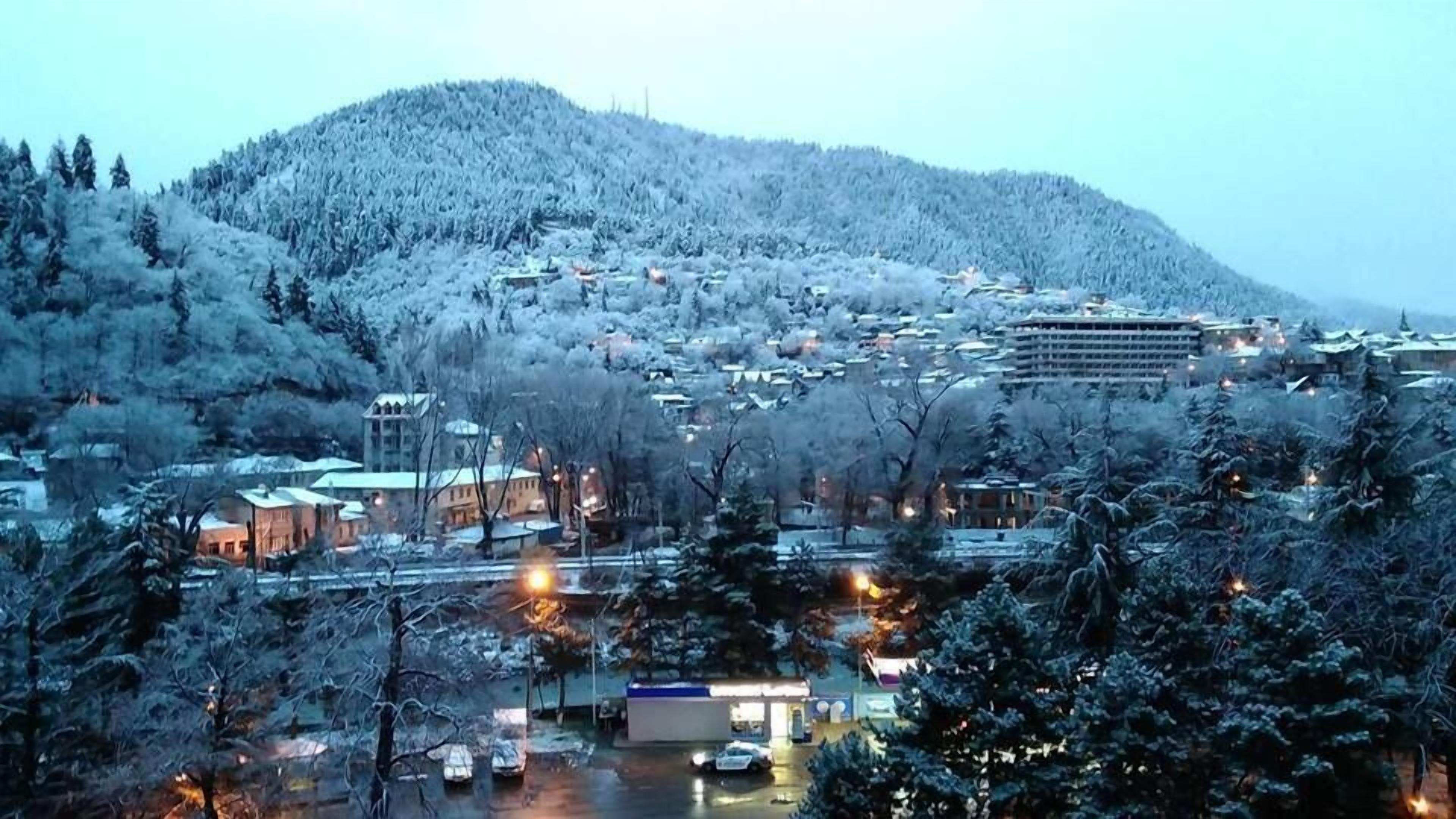 A town with buildings and a mountain in the background.