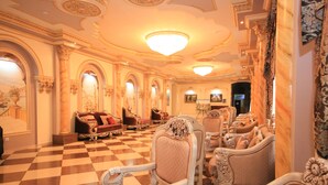 A grand lobby with ornate furniture, a checkered floor, and elaborate ceiling decorations. - Borjomi Palace (Borjomi)