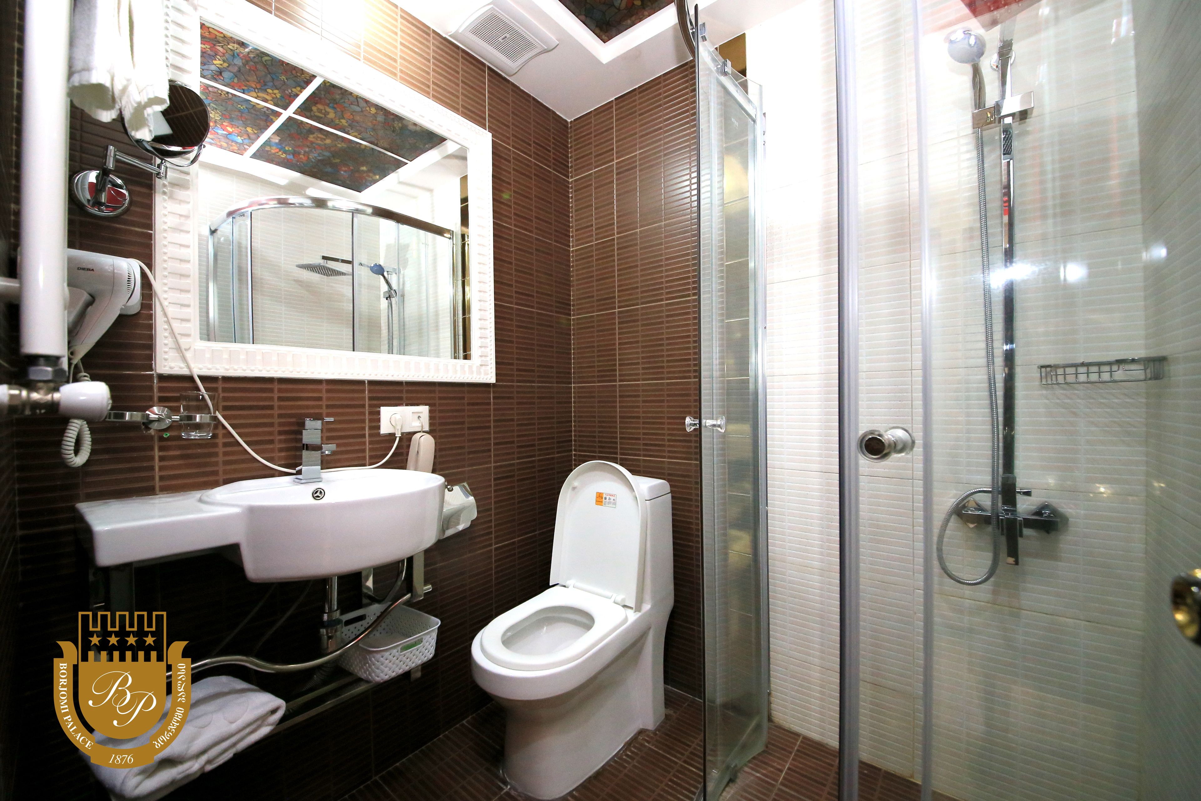 A modern bathroom with a toilet, sink, and shower.