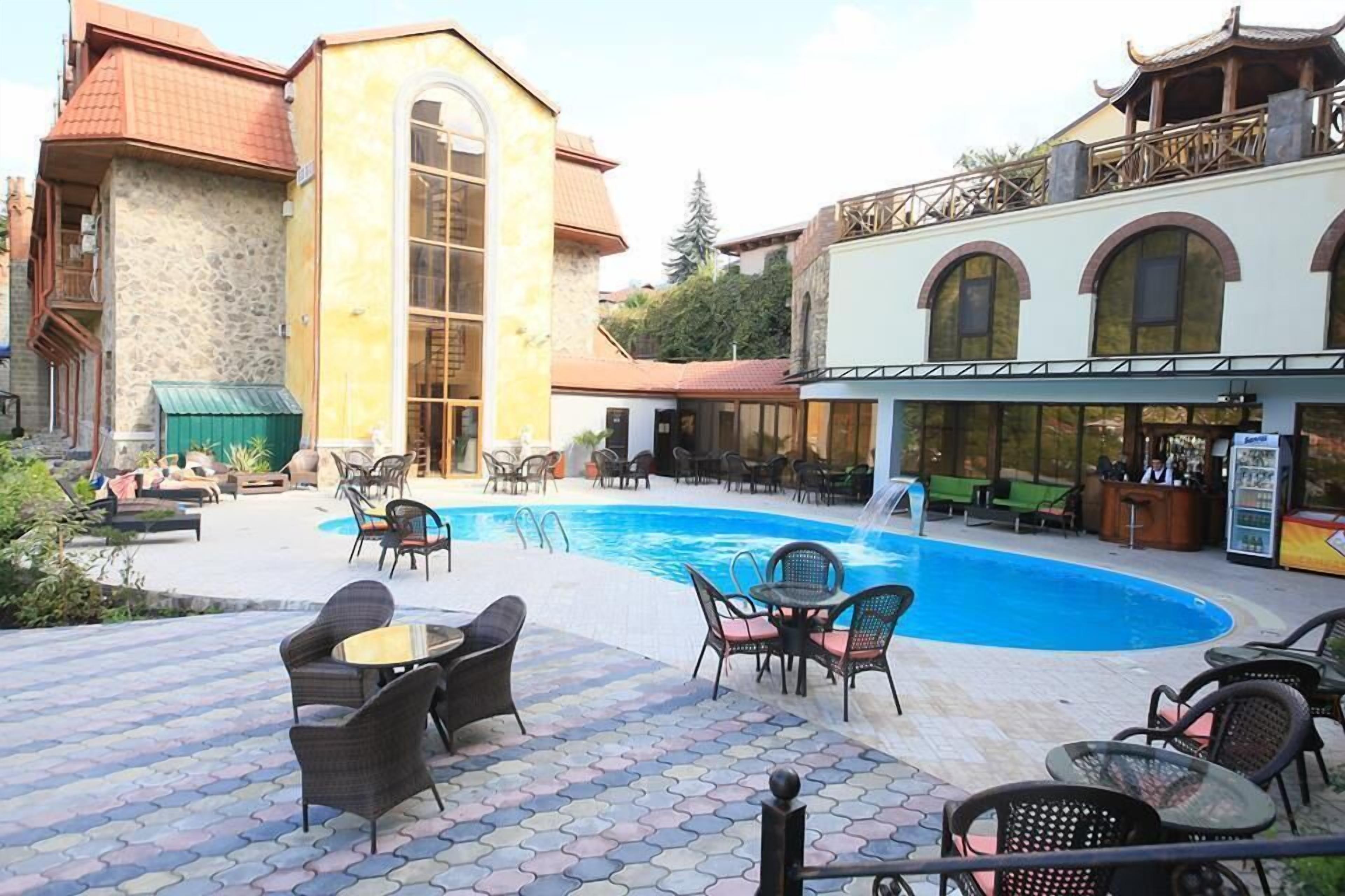 A poolside area with outdoor seating, a bar, and a restaurant with a view of the pool.