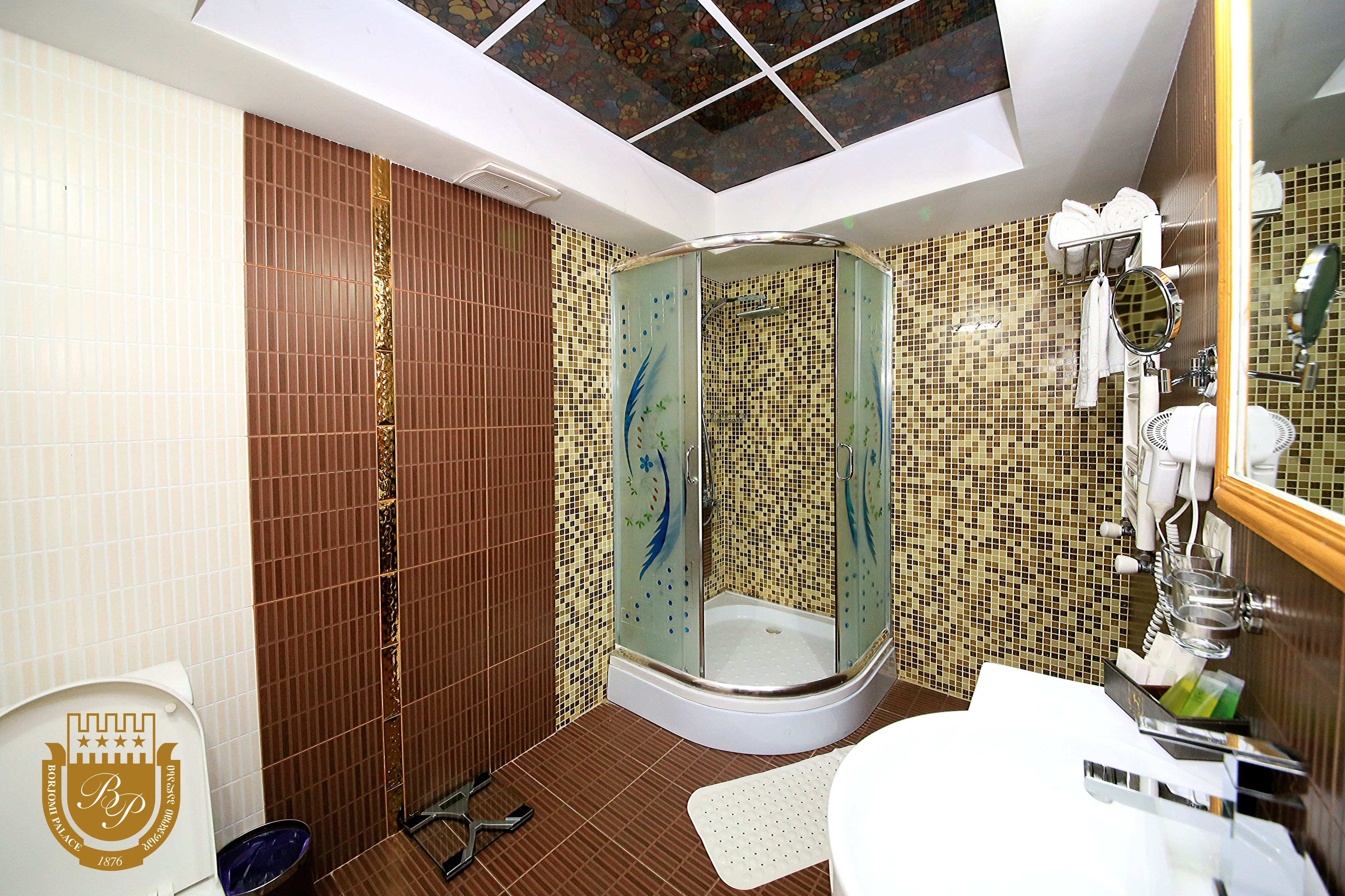 A modern bathroom with a shower, toilet, and sink.