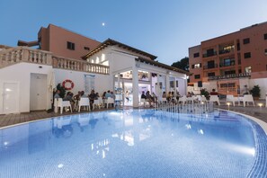 Una piscina al aire libre, sombrillas, tumbonas