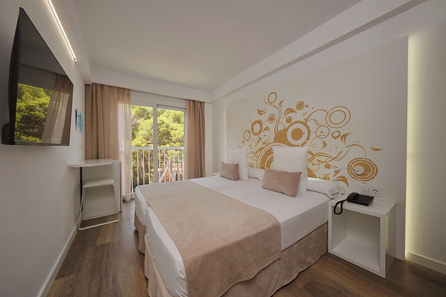Una habitación de hotel moderna con una cama grande, una mesita de noche con un teléfono y una ventana con cortinas.