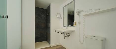 A modern bathroom with a shower, toilet, and sink.