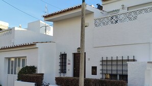 A white building with a tiled roof, a metal gate, and a street lamp. - Lagos Charming Villas (Lagos)