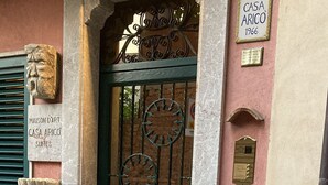 A building entrance with a green door, a metal gate, and a sign reading "CASA ARICO 1966". - Casa Aricò & Shatulle Suites (Taormina)
