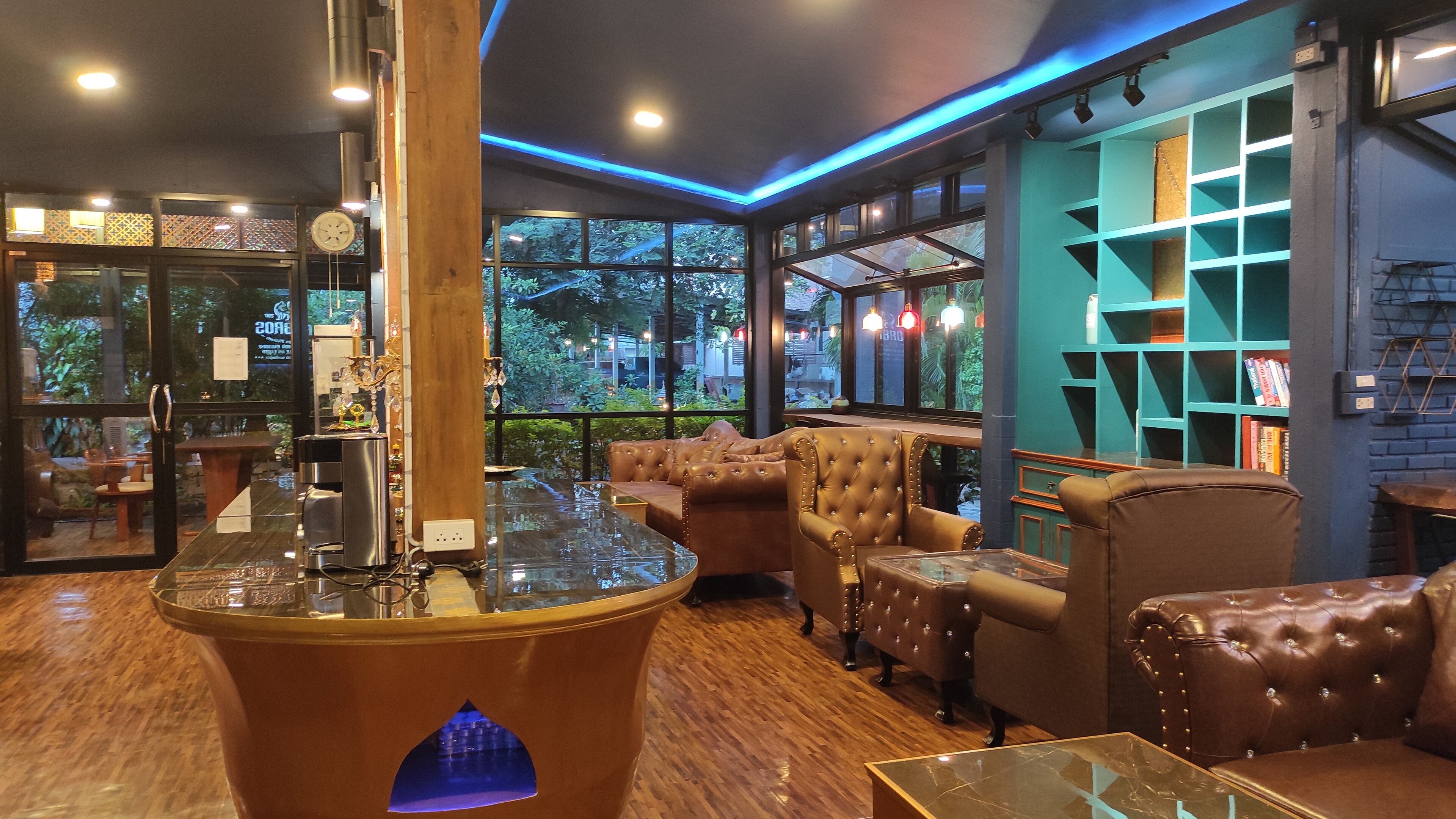 Een modern interieur met leren banken, een glazen salontafel en een houten zuil.