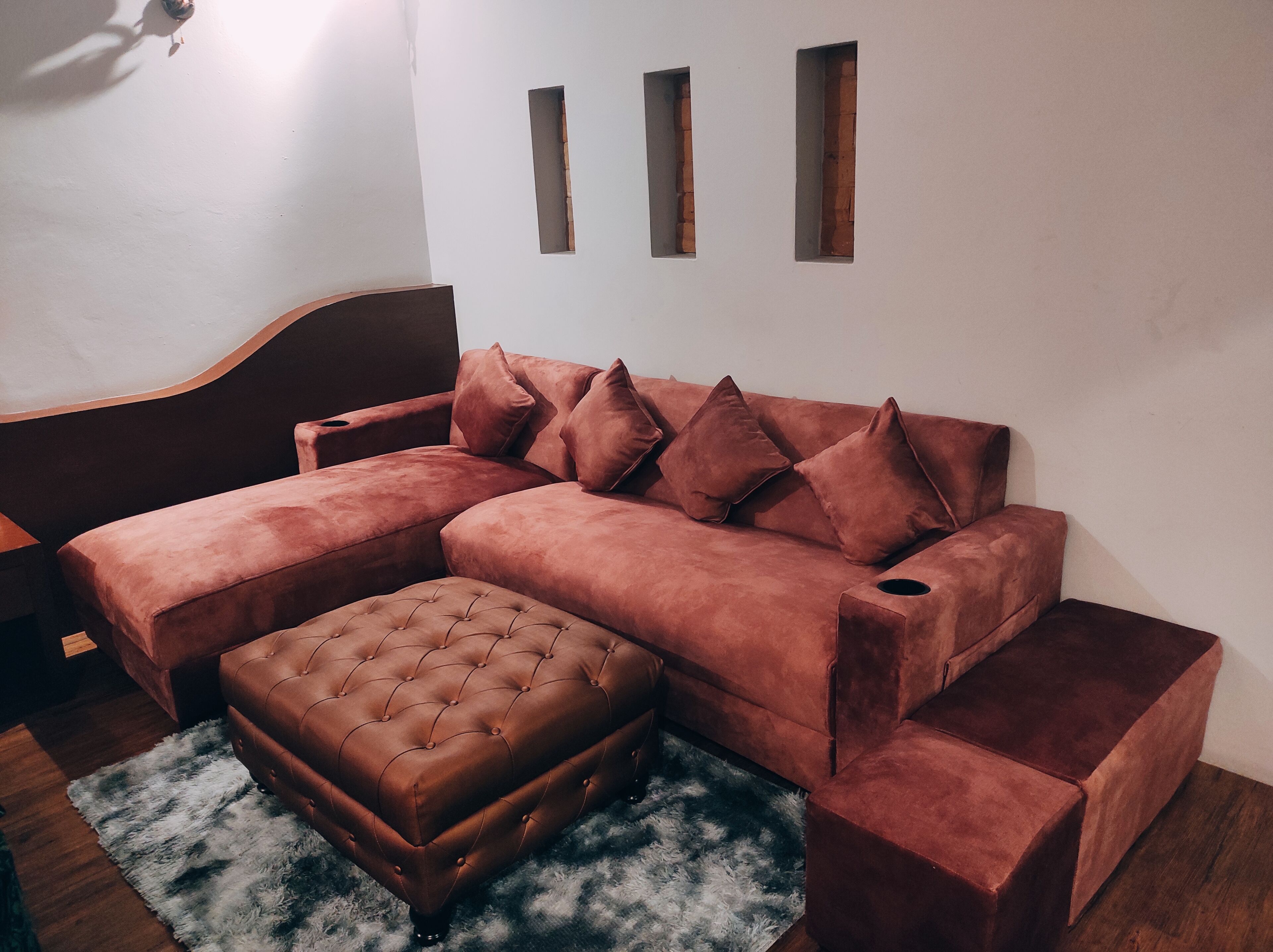 A modern living room with a sectional sofa, a matching ottoman, and a wooden coffee table.
