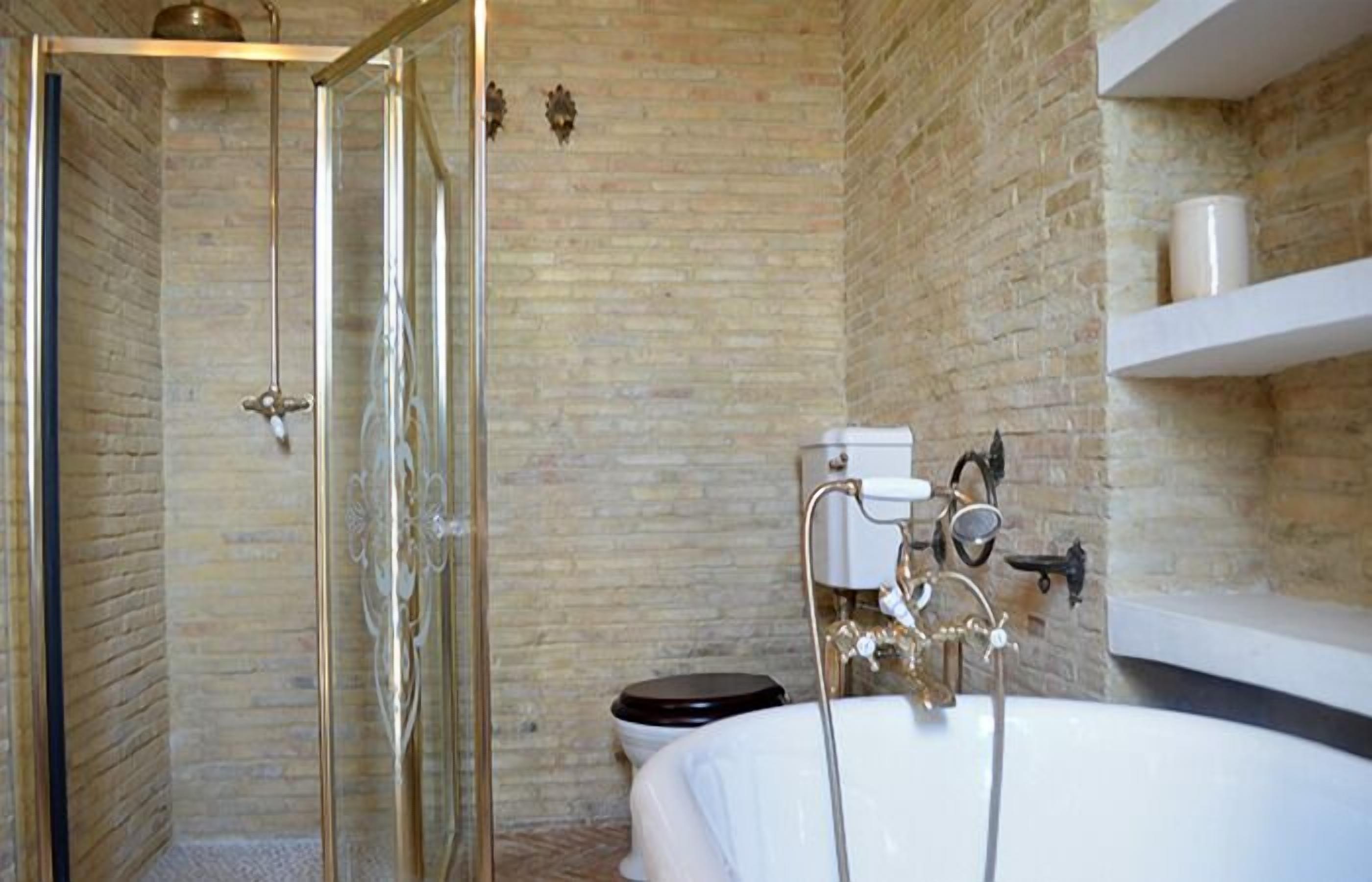 Un baño con ducha envuelta en vidrio, una bañera blanca y un inodoro.