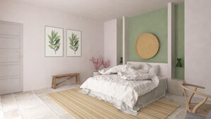 Un dormitorio con una cama, un banco y dos láminas botánicas enmarcadas en la pared.