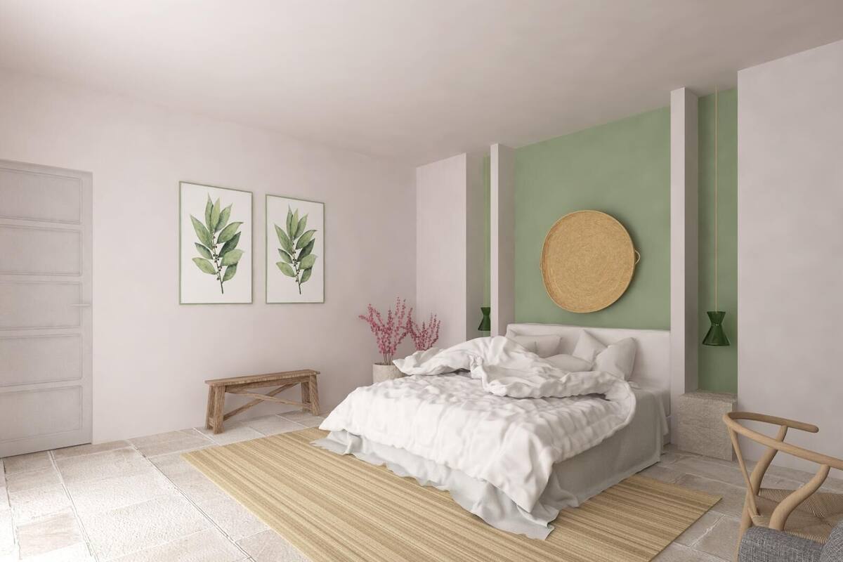 Ein Schlafzimmer mit einem Bett, einer Bank und zwei gerahmten Pflanzenbildern an der Wand.