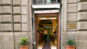 A hotel entrance with a reception desk, a clock, and a sign indicating the hotel name. - Hotel Altavilla 9 (Rome)