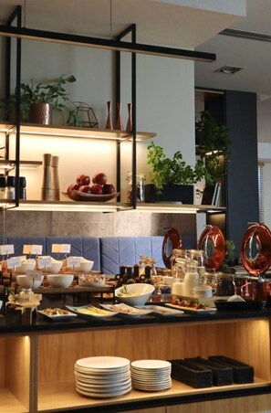 Una cocina moderna con una isla central, estanterías con plantas y una variedad de utensilios de cocina.