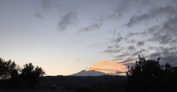 Silueta de una montaña contra un cielo de atardecer con nubes.