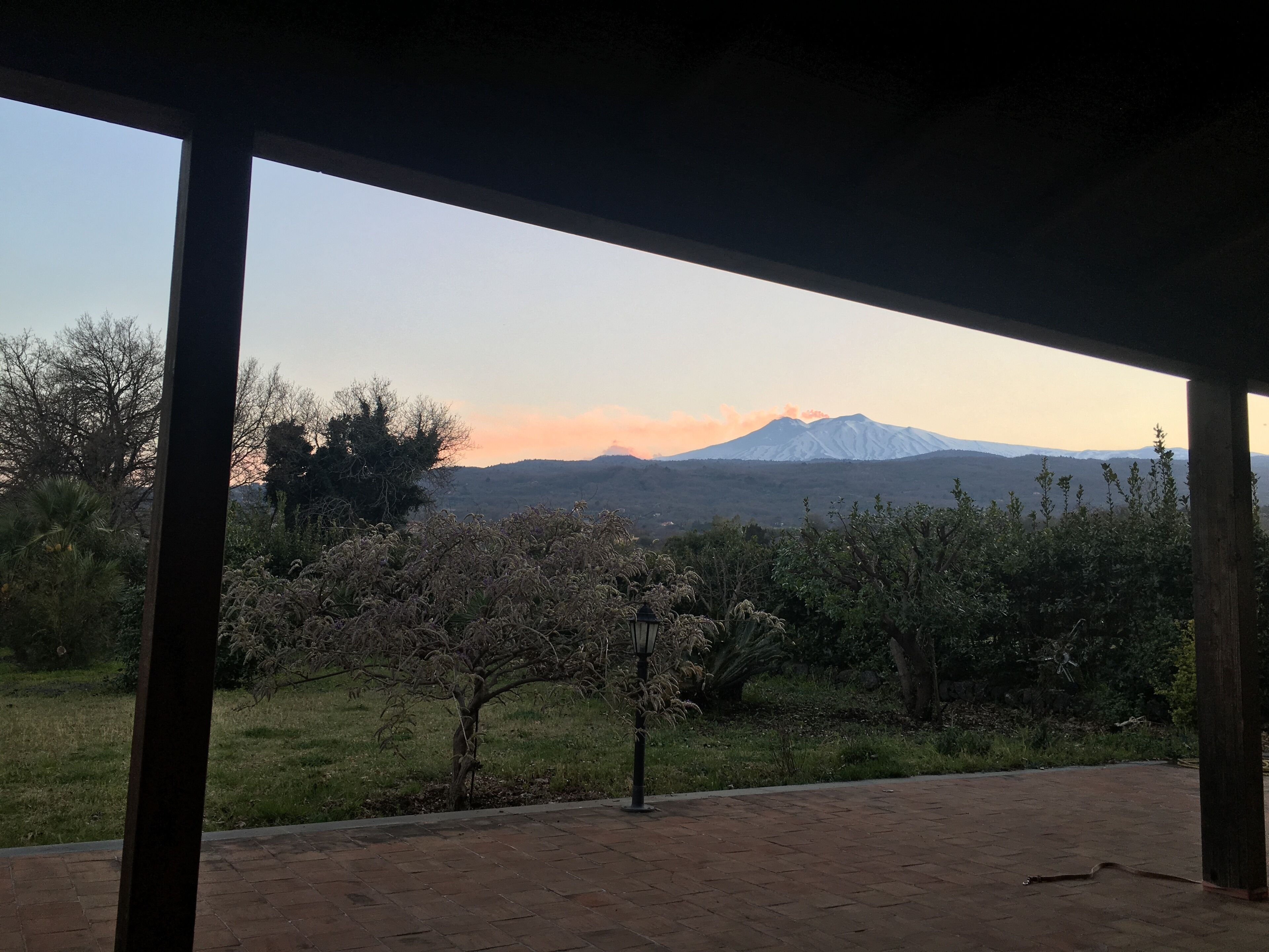 Un espacio al aire libre techado con vista a una cadena montañosa.
