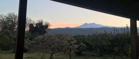 Un espacio al aire libre techado con vista a una cadena montañosa.