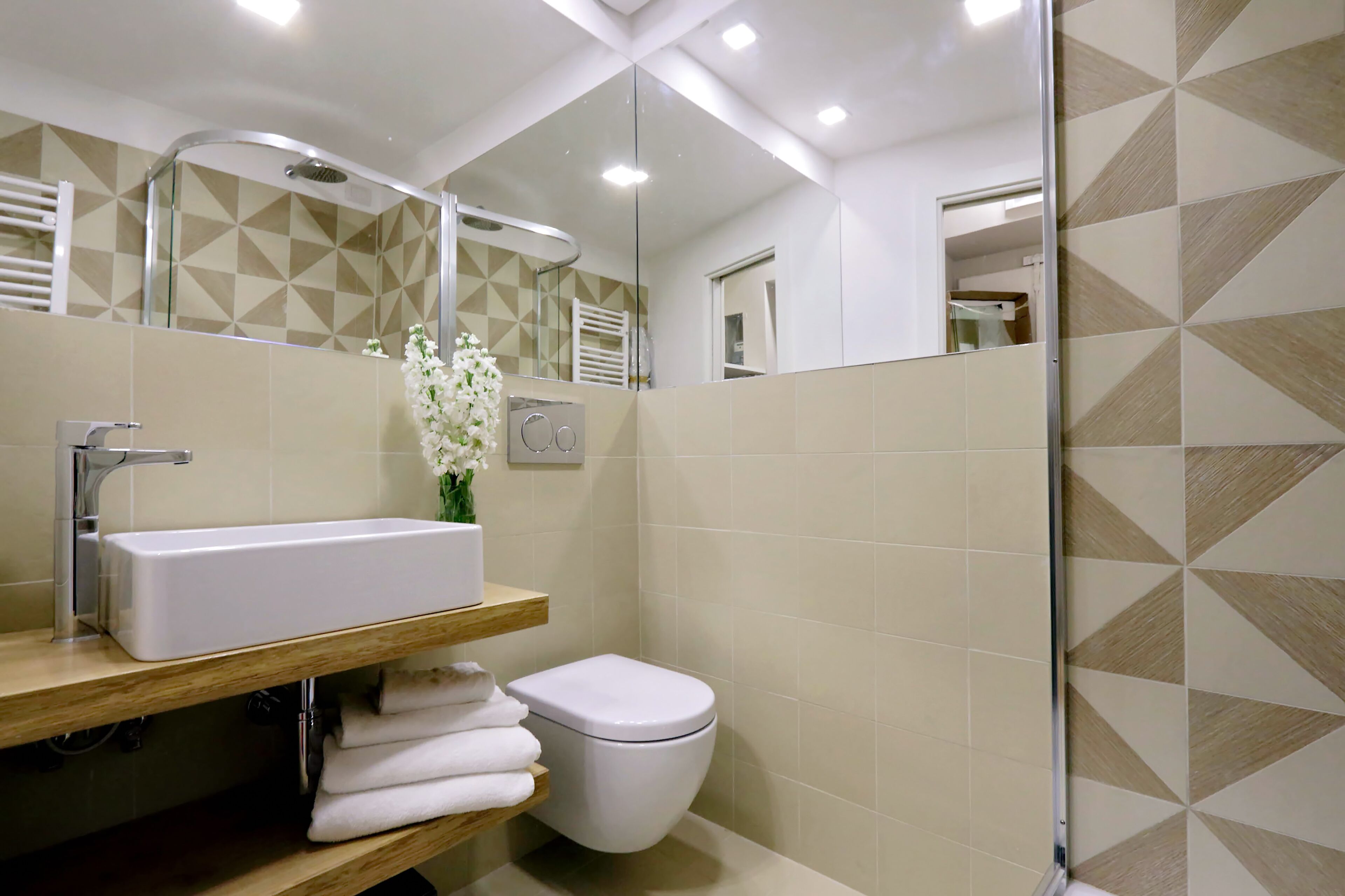 A modern bathroom with a white sink, a toilet, and a shower.