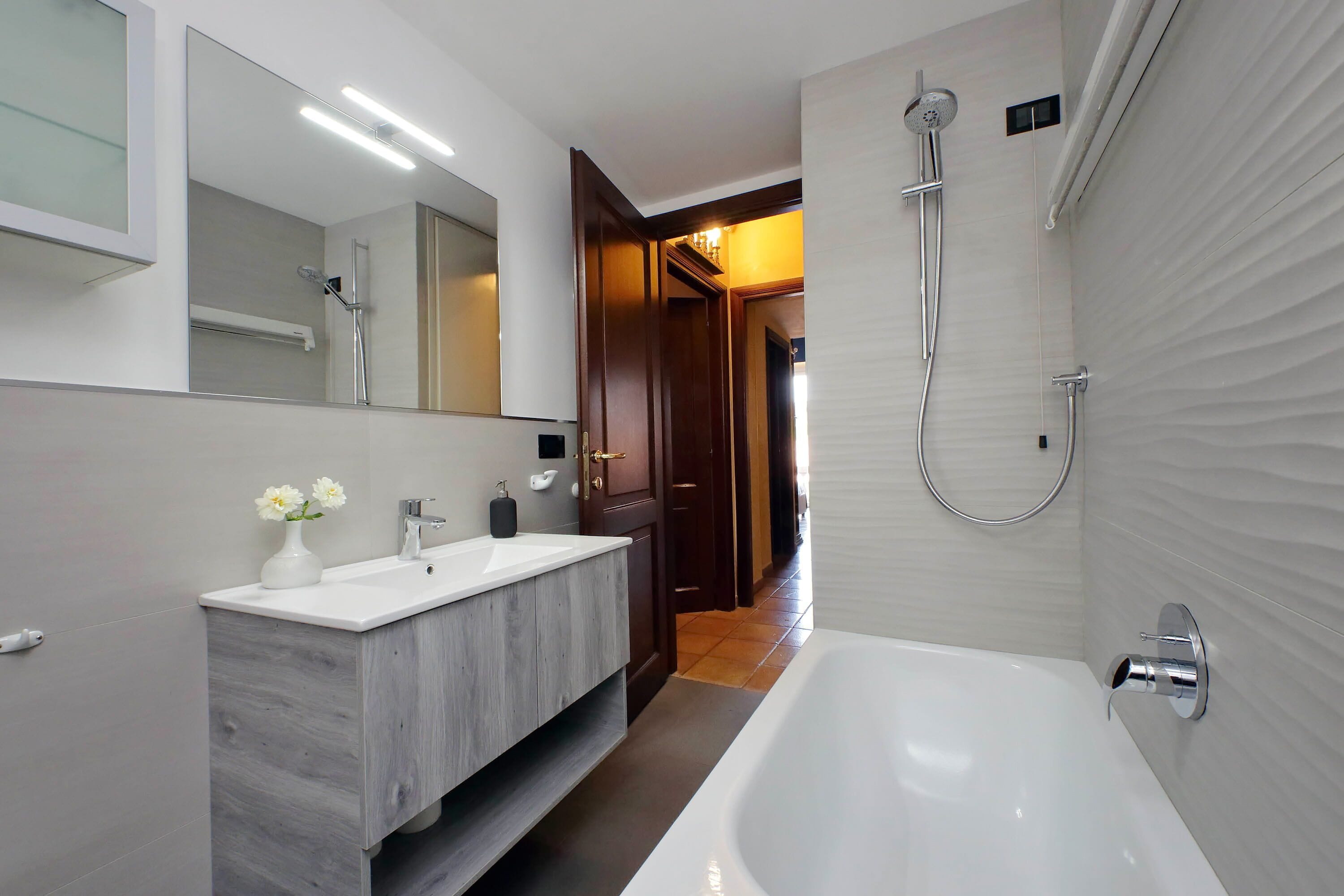 A modern bathroom with a double sink vanity, a large bathtub, and a shower.