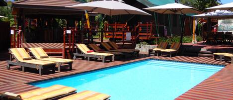 Una piscina al aire libre, camas de piscina gratis, sombrillas