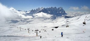 A snow-covered ski slope with ski lifts and a mountain backdrop. - Hotel Scoiattolo (Falcade)