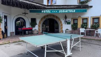 Ein Hotel namens 'SCOIATTOLO' mit einem Tischtennis-Tisch im Innenhof.