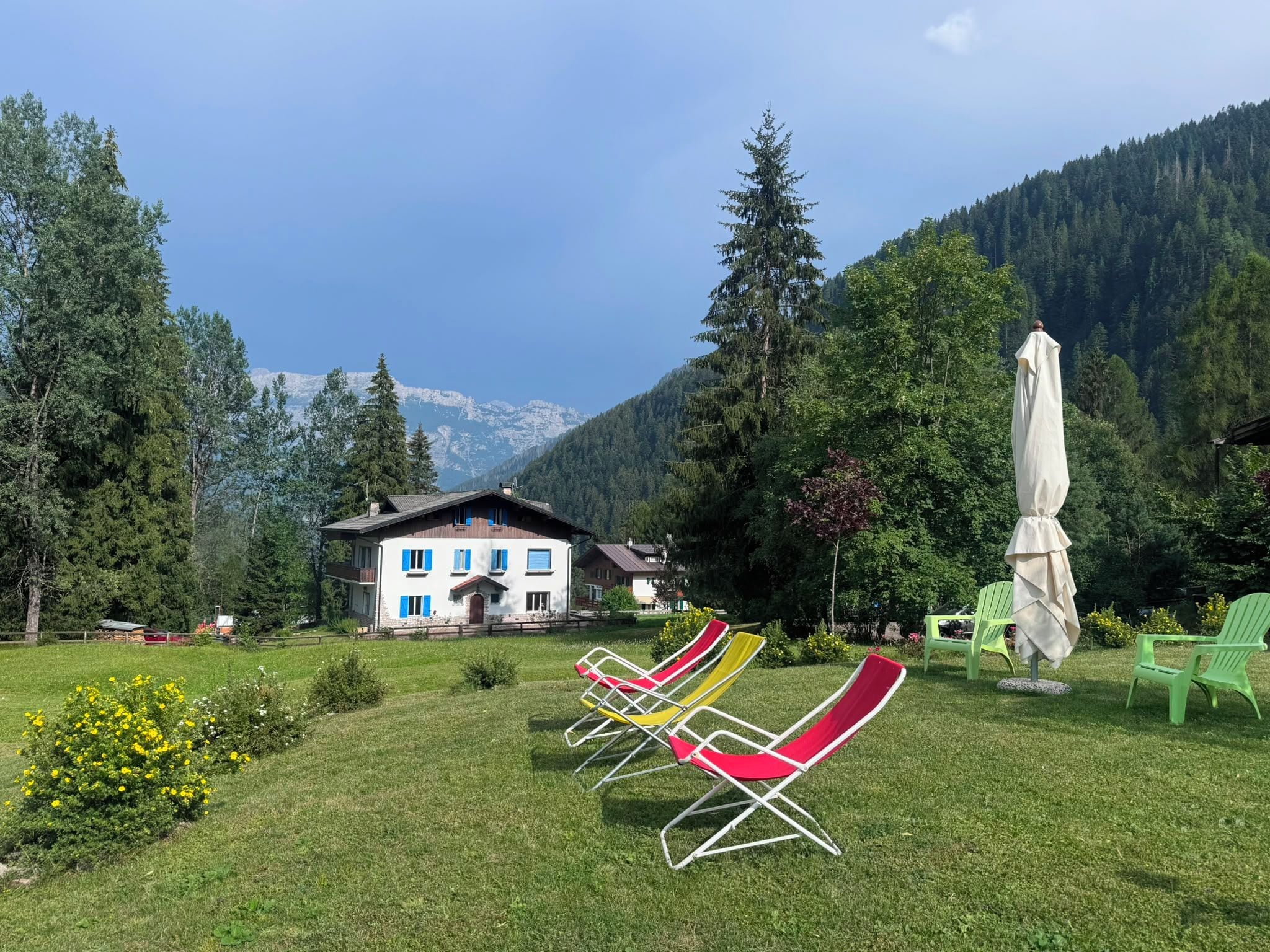 Un chalet avec une vue imprenable sur les montagnes, un espace extérieur aménagé et un ciel dégagé.