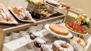 A buffet table with various pastries, including croissants and pies, and a selection of beverages. - Ferrara Rooms (Ferrara)