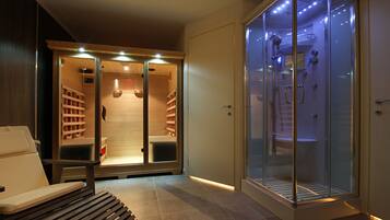 A modern bathroom with a glass-enclosed shower, a bench, and a wooden bench.