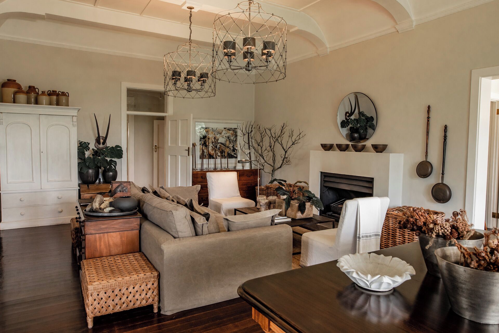 A living room with a sofa, armchairs, a coffee table, a fireplace, and a chandelier.