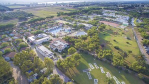 An aerial view of a residential area with houses, a swimming pool, and a park with a fountain. - Nicolaus Club Alimini Smile  (Otranto)