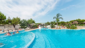 A large outdoor swimming pool with lounge chairs and umbrellas, surrounded by trees and a gazebo. - Nicolaus Club Alimini Smile  (Otranto)