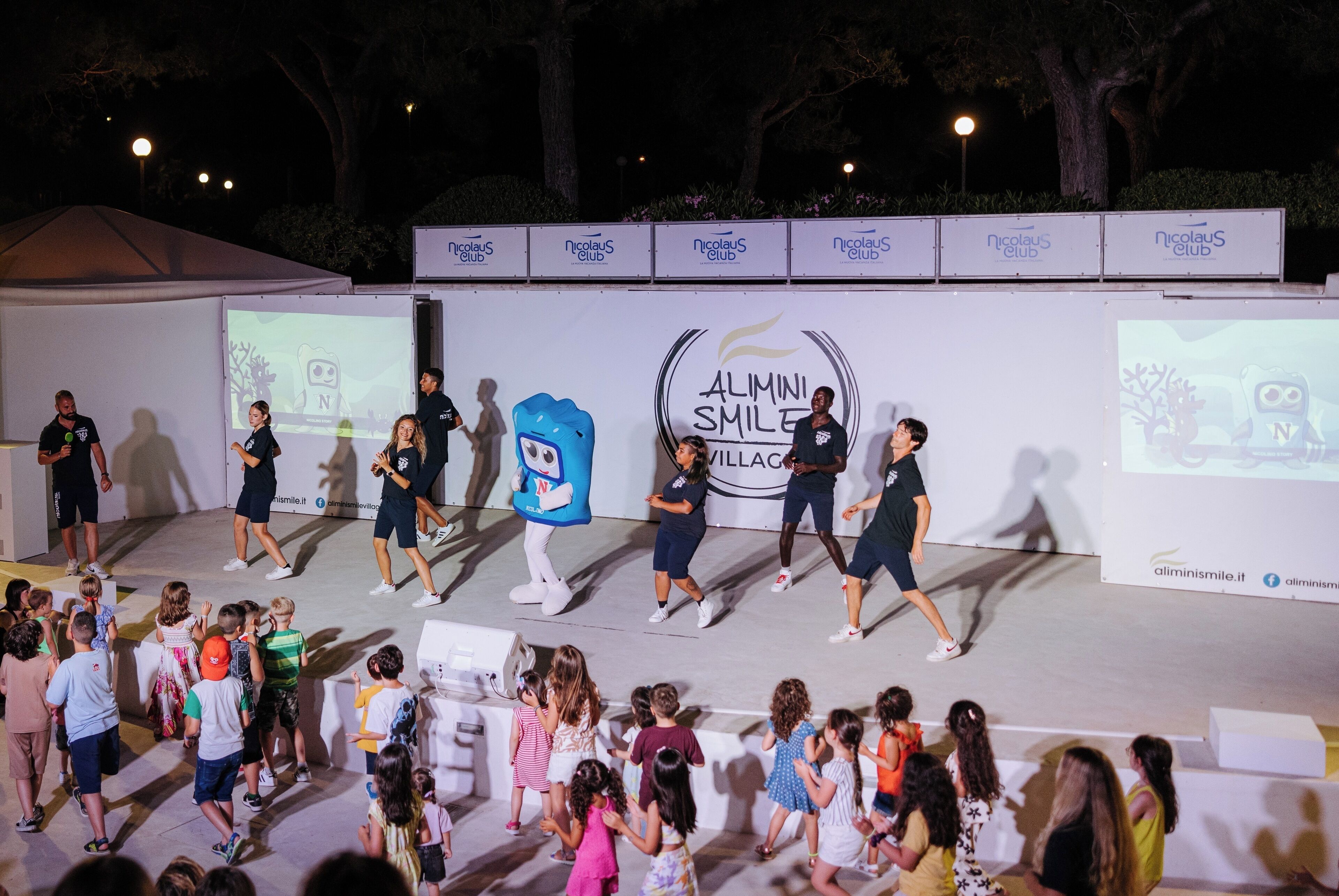 A stage with a mascot and people performing.