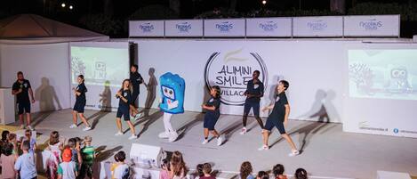 A stage with a mascot and people performing.