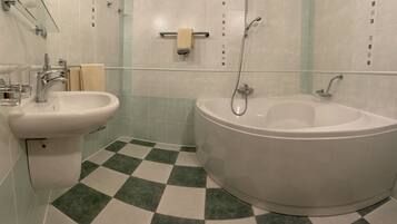 A bathroom with a sink, bidet, and bathtub.