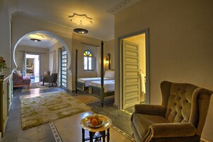 Un'ampia hall d'albergo con un'imponente scalinata, un'area salotto accogliente e vista sulla camera da letto.