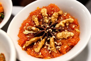 Un plato de comida con nueces y semillas por encima.